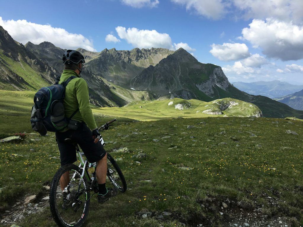 man riding bicycle on top of mountain fietsen in de alpen