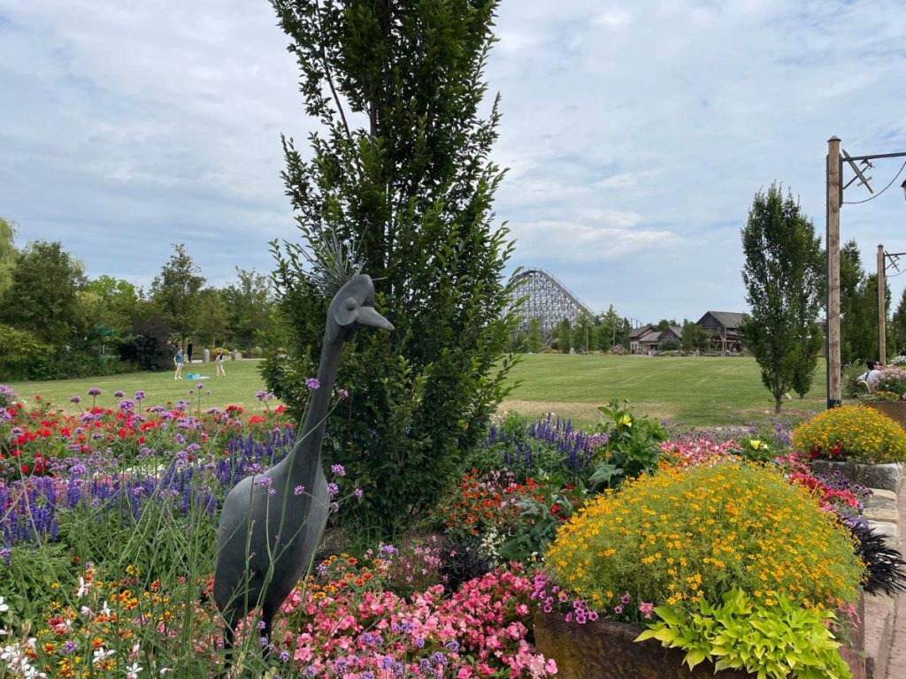 beeld van vogel met bloemen en achtbaan op de achtergrond